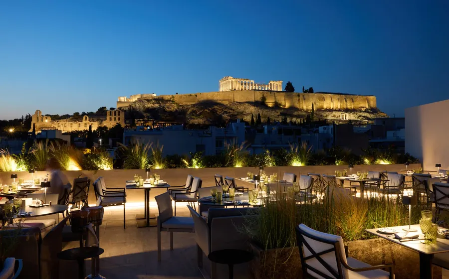Divani Collection Hotels in Athens: a rooftop at dusk facing the lit Parthenon